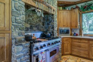 Vieille cuisine avec meubles en bois et murs en pierre