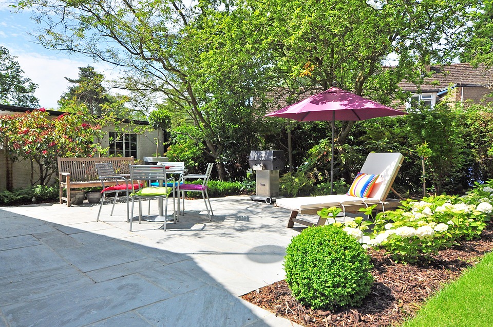 Terrasse entourée d'un jardin fleuri avec de nombreuses plantes