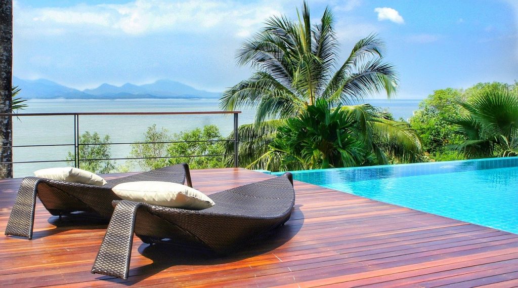 terrase en bois avec des transats au bord d'une piscine