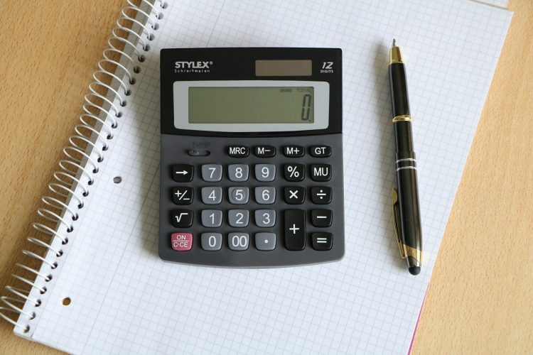 calculatrice et stylo posés sur un cahier